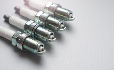New automobile spark plugs on a gray background with copy space