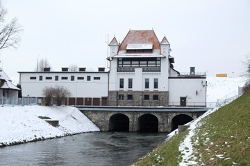 Obraz premium The building of the hydroelectric power plant in Straszyn in winter scenery. Kashubia, Poland