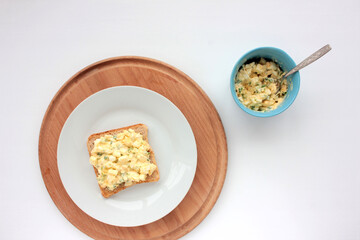 Egg salad sandwich with whole wheat toasted bread and microgreens on plate on white background. Healthy food concept
