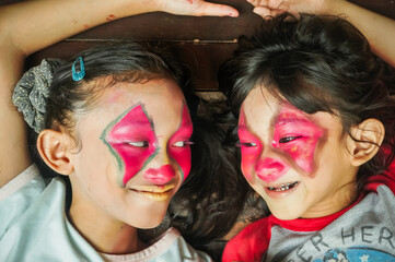 Obraz premium Portrait of cute Asian children with funny clown make-up on their face