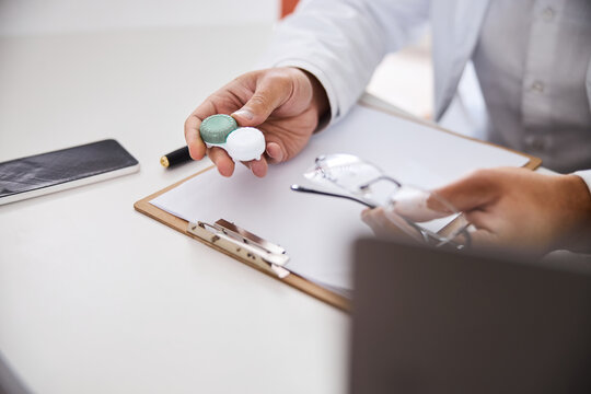 Male Optician With Contacts And Spectacles Sitting At The Desk