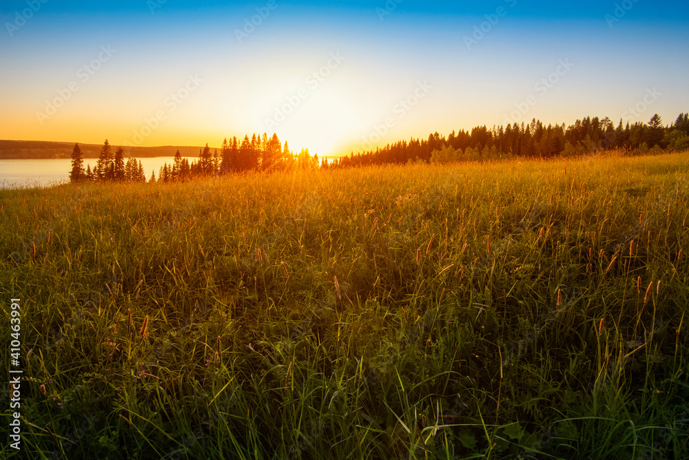 Wall mural panoramic view of the kama river from the hill, green meadow, rural road, sunset sky and sun rays.