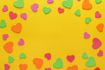 Multicolored hearts on yellow background. Blank center for text