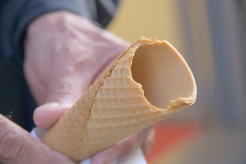 male senior hand is holding a broken ice cream cone