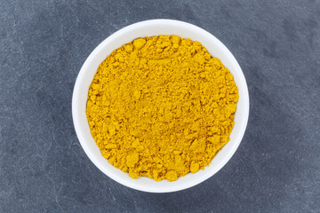 Curry powder spice from above bowl on a slate