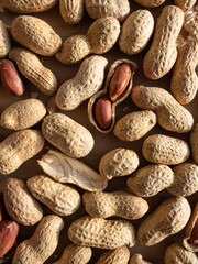 Peanuts in shells and peeled scattered on brown craft paper in the morning light