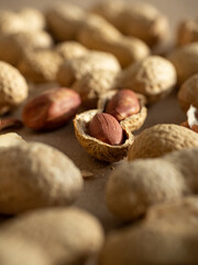 Peanuts in shells and peeled scattered on brown craft paper in the morning light