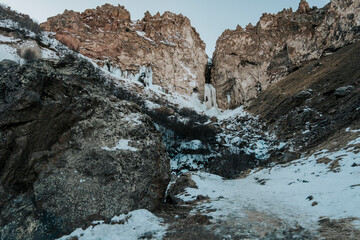 Photo of a frozen waterfall in the mountains in winter. Mountains of Russia, North Caucasus. 