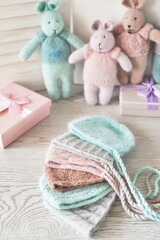 Obraz na płótnie Canvas Needlework and knitting. Hobbies and creativity. Knit for children. Knitted toys rabbit and hat. Handmade toy hare. Baby cap. Yarn, threads and balls