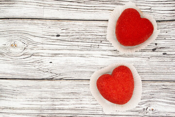A bright red heart-shaped cakes on a wooden background. Copy space