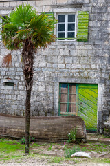 Abandoned and rotting boat in front of a boarded up dwelling in the village of Donji Stoliv, Bay of Kotor, Montenegro