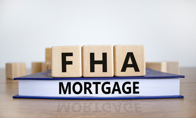 FHA mortgage symbol. Wooden blocks and book with words 'FHA mortgage'. Beautiful white background, copy space. Business and FHA - federal housing administration mortgage concept.