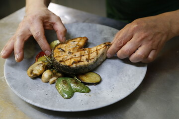 Fisch gegrillt, Gemüse auf Teller anrichten