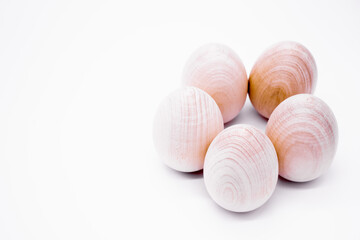 Fototapeta na wymiar Five hand-made unpainted wooden eggs on a white background