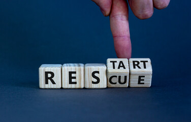 Rescue and restart symbol. Businessman hand turns cubes and changes the word 'rescue' to 'restart'. Beautiful grey background. Business and rescue - restart concept. Copy space.