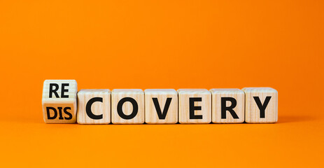 Recovery or discovery symbol. Turned a wooden cube, changed a word 'discovery' to 'recovery'. Beautiful orange background. Business and discovery or recovery concept. Copy space.