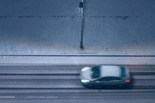 Car On City Winter Road In The Evening. Motion Blur, Defocused, Top View