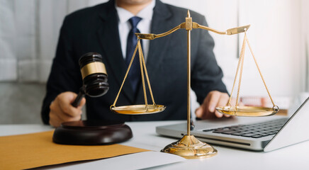 Justice and law concept.Male judge in a courtroom with the gavel, working with, computer and...