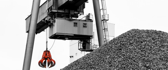 Hydraulic Clow Crane used for picking up scrap metal at recycling yard. In the foreground gravel...