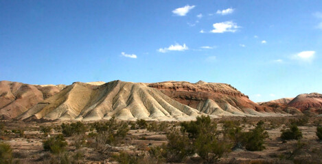 Aktau Mountains on sunrise. Beautiful landscape of colorful mountains in desert. Nature reserve Altyn Emel. Kazakhstan. Panorama with copy space