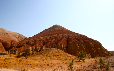 Aktau Mountains on sunrise. Beautiful landscape of colorful mountains in desert. Nature reserve Altyn Emel. Kazakhstan. Panorama with copy space
