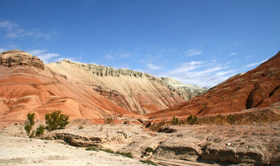 Aktau Mountains on sunrise. Beautiful landscape of colorful mountains in desert. Nature reserve Altyn Emel. Kazakhstan. Panorama with copy space