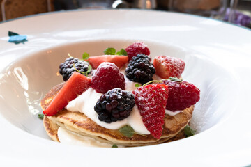 American style pancakes with fresh berries and cream sauce