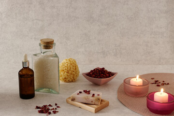 Fototapeta na wymiar Natural cosmetics on bright background. Rose soap, bath salt and candles. Romantic bathing arrangement.