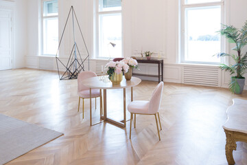 chic spacious light room in an old mansion in the classical style of the 19th century with a high ceiling decorated with stucco on white walls