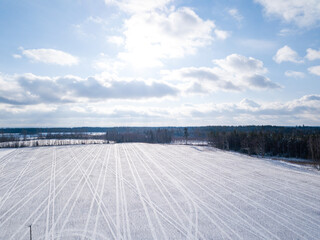 White snowy field on a sunny day with blue sky and white clouds in them