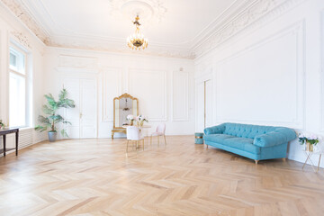 chic spacious light room in an old mansion in the classical style of the 19th century with a high ceiling decorated with stucco on white walls