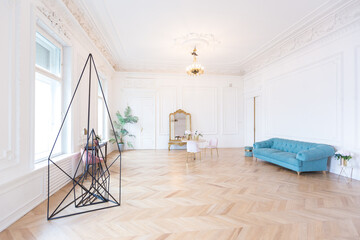 chic spacious light room in an old mansion in the classical style of the 19th century with a high ceiling decorated with stucco on white walls