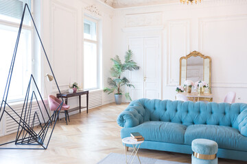 chic spacious light room in an old mansion in the classical style of the 19th century with a high ceiling decorated with stucco on white walls