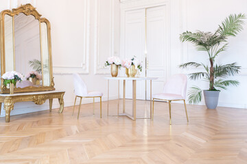 chic spacious light room in an old mansion in the classical style of the 19th century with a high ceiling decorated with stucco on white walls