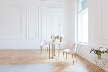chic spacious light room in an old mansion in the classical style of the 19th century with a high ceiling decorated with stucco on white walls