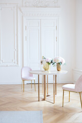 chic spacious light room in an old mansion in the classical style of the 19th century with a high ceiling decorated with stucco on white walls