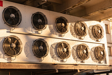 Condenser fan unit installed lined on the side of the building. Condenser fan unit for cooling of...
