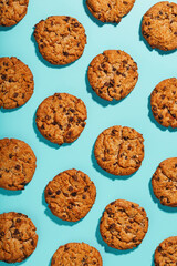 Oatmeal cookies with chocolate chip pattern and patterns on a light blue background. Full screen, top view