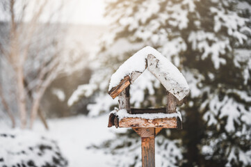 Fototapeta premium Bird feeder on a pole with snow on the roof.