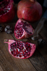 Pieces of fresh pomegranate on a dark wooden background. Food background. 