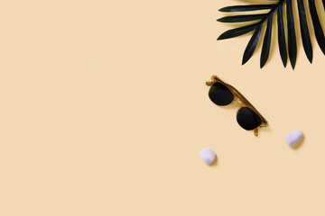 Sunglasses and palm leaf in flat lay composition about holidays and summer