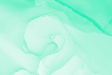 Swirling wave of fabric on a light green background