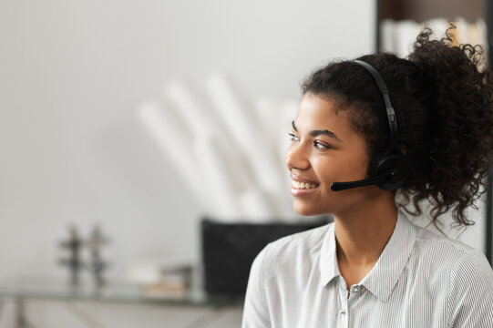 Young Thoughtful African American Female Sudent In A Headset Is Listening To An Online Webinar, Studing Remotely From Home Or Working In The Customer Service Department As A Call Center Operator