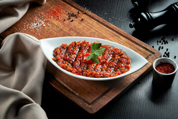 A spicy Turkish appetizer ezme made with tomatoes, bell pepper, parsley, mint, olive oil and hot chili. A kind of adjika