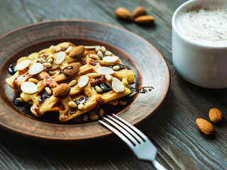 Viennese waffles with chocolate and nuts and a cup of cappuccino