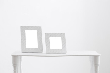 two frames on wooden shelf on white background