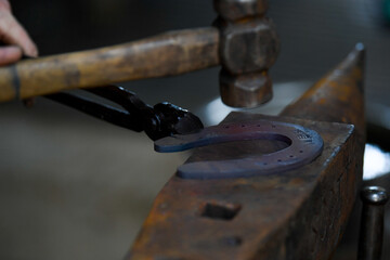 A farrier adjusting a horseshoe 