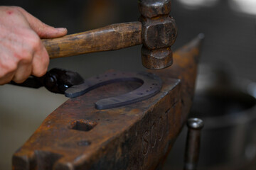 A farrier adjusting a horseshoe 