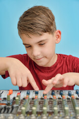Stylish boy customizes the keys and buttons on the mixing console by winding fenders.