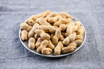 Roasted peanuts. Tasty groundnuts on plate.